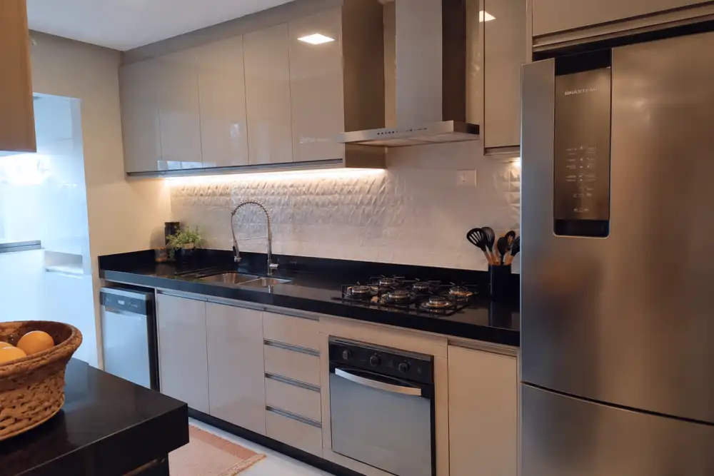 Cozinha planejada com ilha e acabamento amadeirado em Guaratinguetá